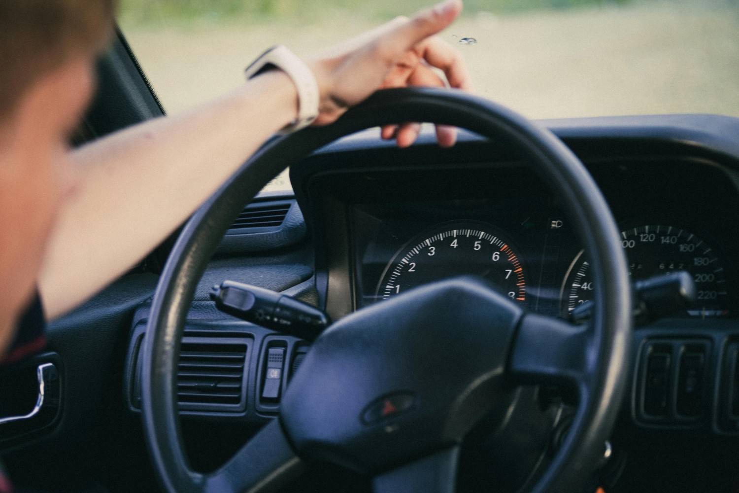Close up of hands on a modern steering wheel with safety indicators
